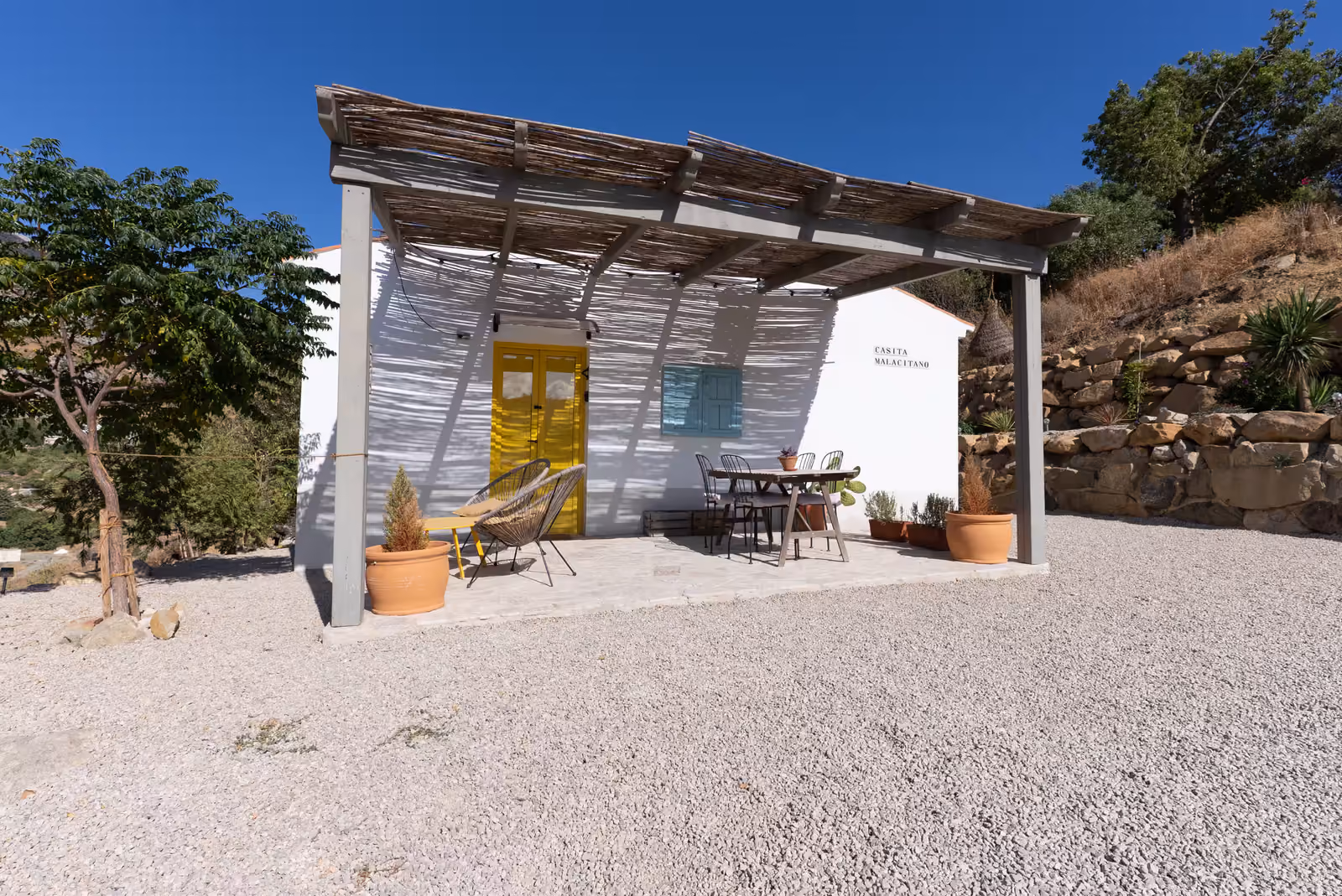 Casita Malacitano exterior with pergola and yellow door